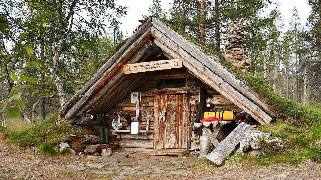 A hut with a turret roof and a stone chimney.