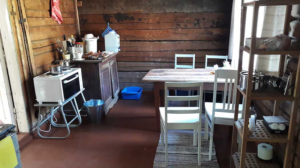 The kitchen inside the hut, and a dining table and chairs.