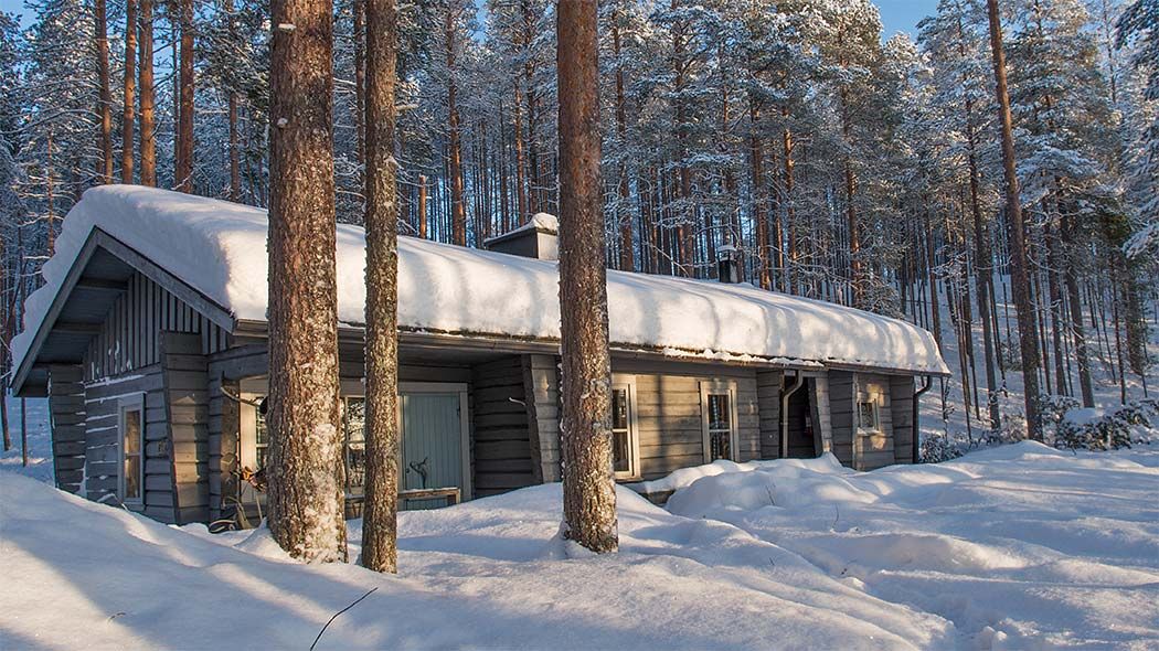 Talvisessa metsässä on iso talo.