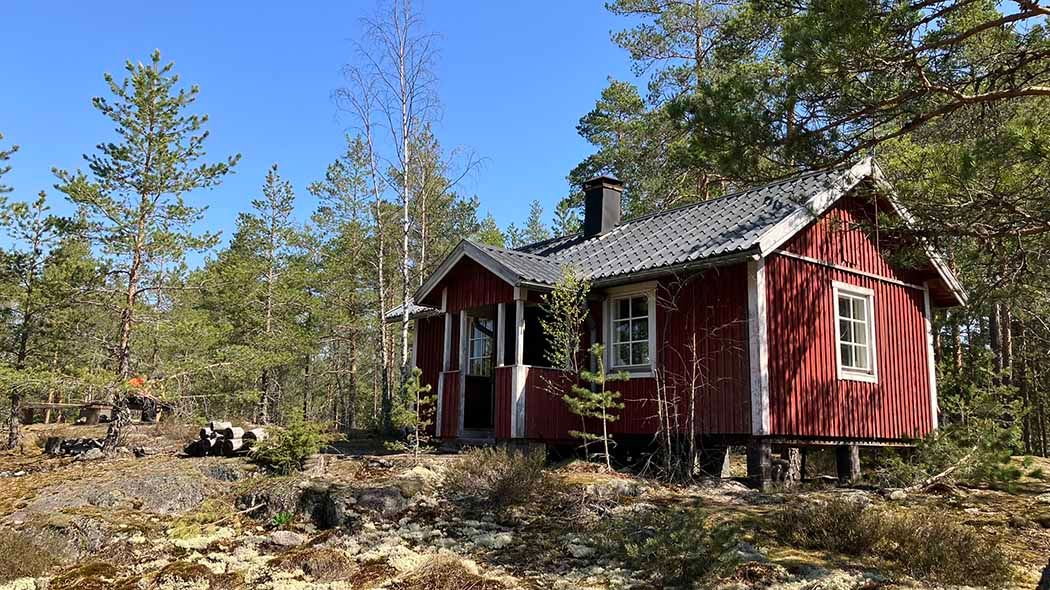 A small hut on the hill, surrounded by forest.