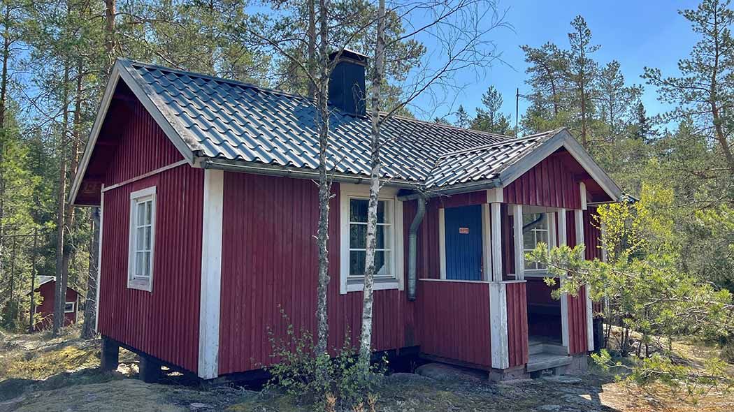 A small hut on the hill, surrounded by forest.