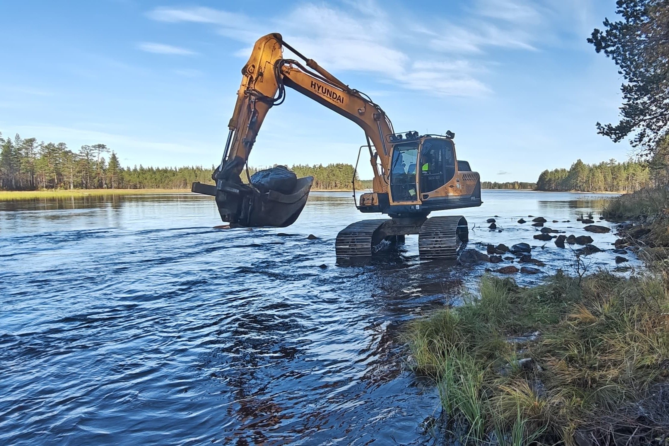 Kaivinkone matalassa vedessä.