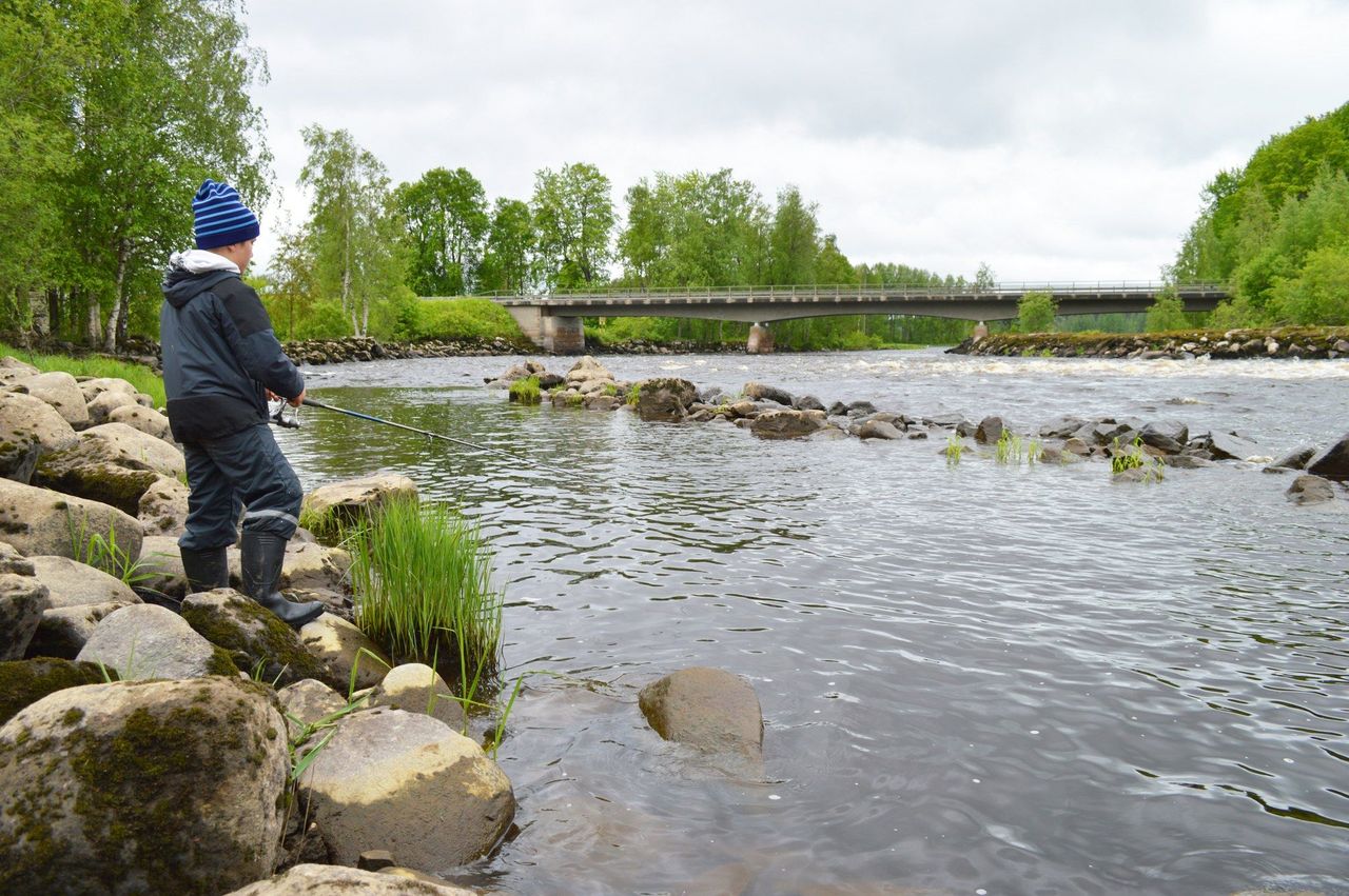 På bilden till vänster en fiskare på Viannankoski strandsten. Viannankoski-bron syns i bakgrunden.
