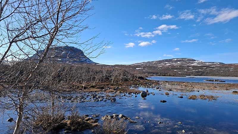 Järven taustalla siintää jyrkkärinteinen tunturi.